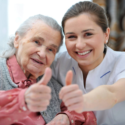 senior woman and female caregiver are showing thumbs up