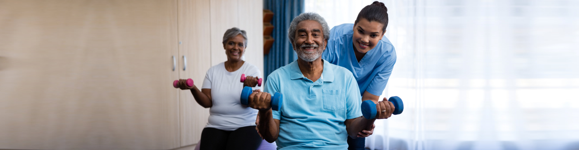 Portrait of nurse training seniors in lifting dumbbells at nursing home